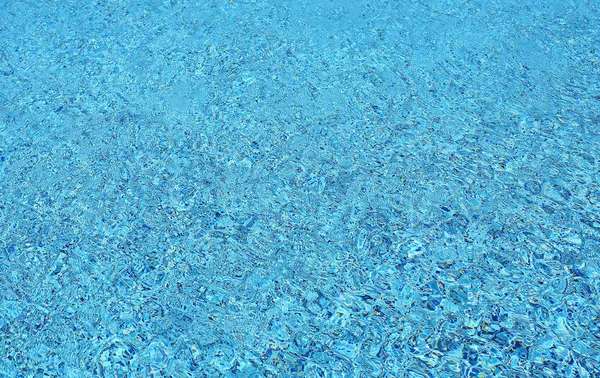 Onda de água na piscina com reflexos de luz. Textura de fundo . — Fotografia de Stock