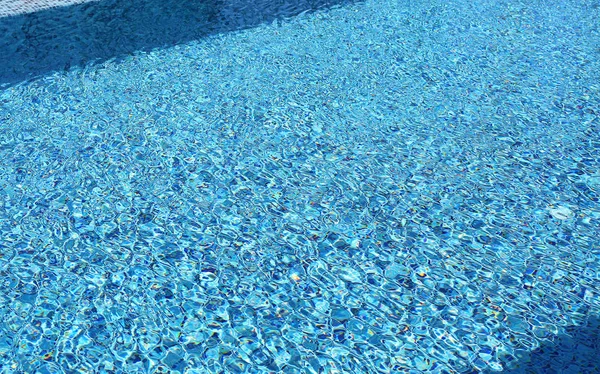 Onda d'acqua in piscina con luce riflettente. Struttura di sfondo . — Foto Stock