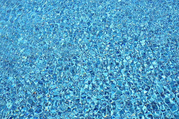 Onda de água na piscina com reflexos de luz. Textura de fundo . — Fotografia de Stock