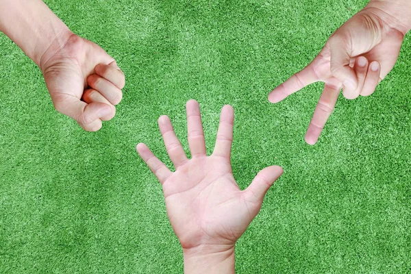 Närbild Rock, papper, sax - händer på grönt gräs bakgrund — Stockfoto