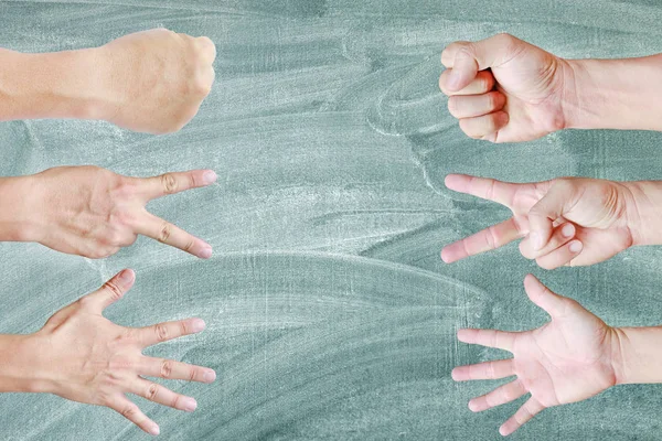 Many hands of Rock ,Paper ,Scissors - hands on blackboard background, Creative concept.