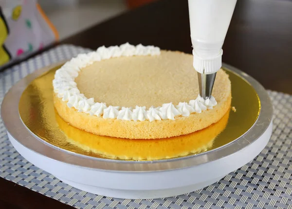 Cake in process on stand on wooden table, Homemade Cake. — Stock Photo, Image