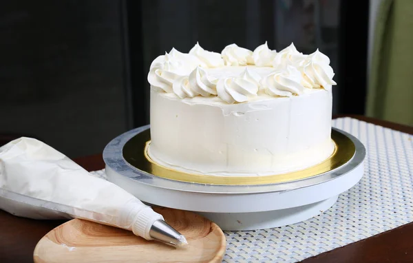Taart in proces op stand op houten tafel, zelfgemaakte Cake. — Stockfoto