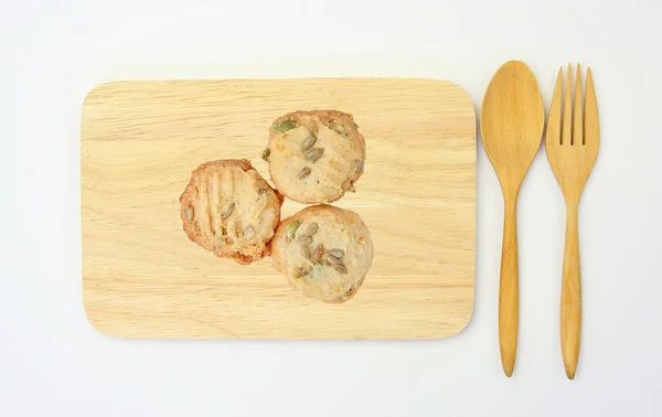 Pohled shora souborů cookie na dřevěnou destičku a vařečku na bílém pozadí. — Stock fotografie