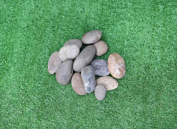 Камни на траве, круглые камни на фоне травы — стоковое фото