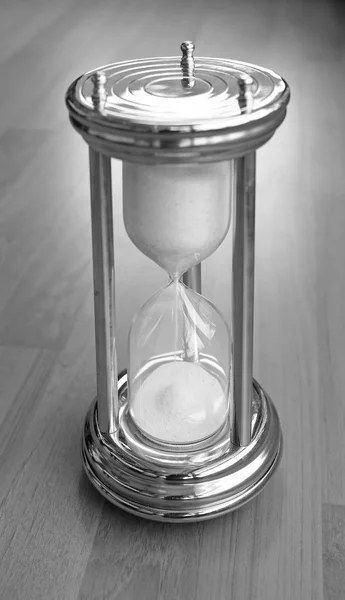 Пісочний годинник на дерев'яному фоні, чорно-білий тон — стокове фото