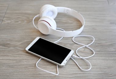 kulaklık ve ahşap arka plan üstünde smartphone