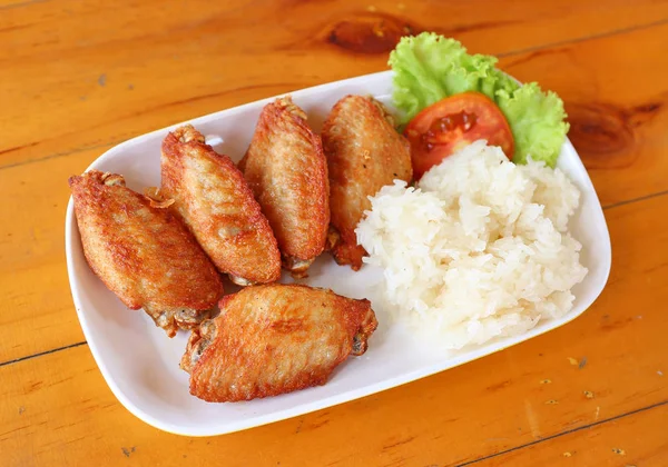 buffalo chicken wings with sticky rice on white plate