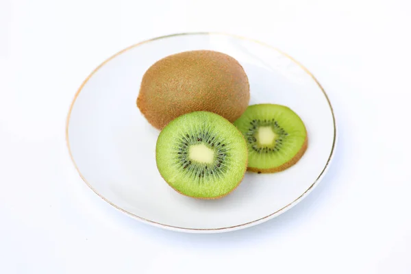 Buah kiwi di piring putih pada latar belakang putih — Stok Foto