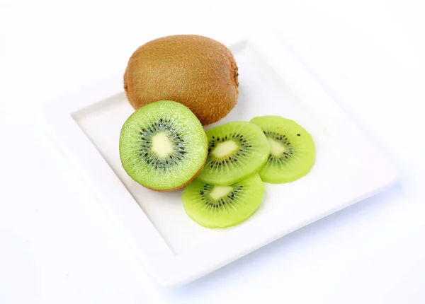 Buah kiwi di piring putih pada latar belakang putih — Stok Foto