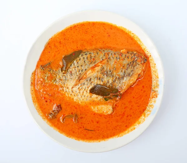 Spicy hot tilapia fish curry in white plate against white background
