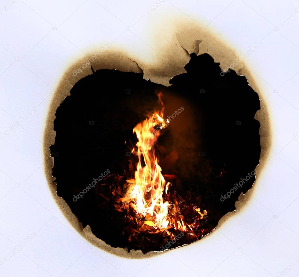 Frame of burned hole in paper like a heart with Fire background.