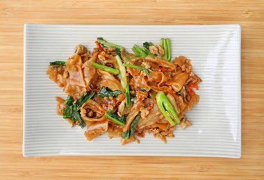 Kızarmış düz şehriye ve domuz koyu soya sosu ile ahşap arka plan üzerine ilave edin