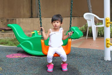 Şirin çocuk kız eğlence Bahçesi bir salıncak üzerinde