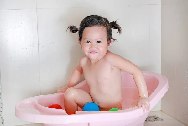 Κοριτσάκι λούζει με ροζ μπανιέρα με ένα παιχνίδι — Φωτογραφία Αρχείου