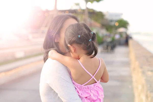 Mutlu sevgi dolu aile. Anne kızı çocuk kızı deniz arka plan üzerinde akşam sarılma. — Stok fotoğraf