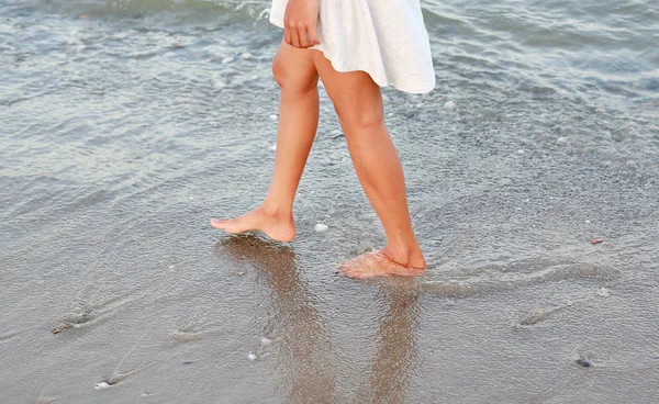 Young woman in white dress walking alone on the beach — Stock Photo, Image