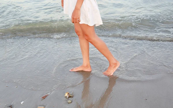 Mujer joven en vestido blanco caminando sola en la playa — Foto de Stock