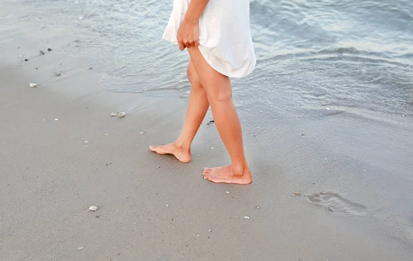 Fiatal nő fehér ruhában séta egyedül a tengerparton — Stock Fotó