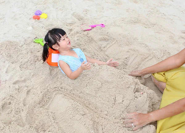 Happy loving family. Mother and her daughter child girl playing sand at the beach — Stock Photo, Image