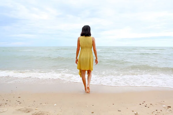 Mujer joven caminando sola en la playa, ir directamente al mar — Foto de Stock