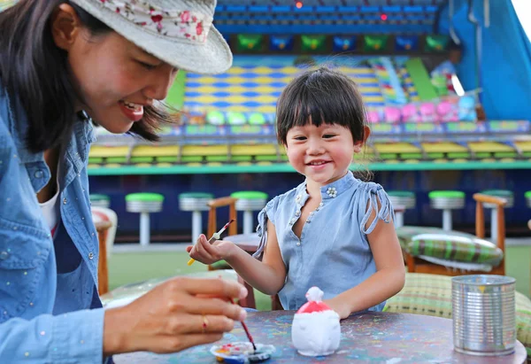 Madre y niña divirtiéndose para pintar en la muñeca de estuco — Foto de Stock