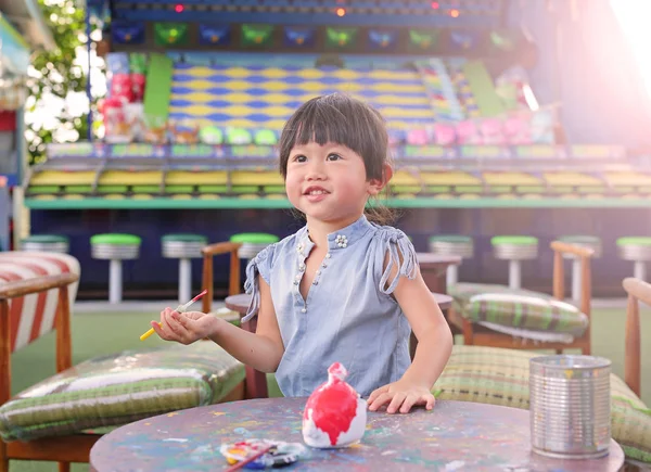 Peinture d'enfant, Portrait petite fille s'amusant à peindre sur poupée en stuc — Photo