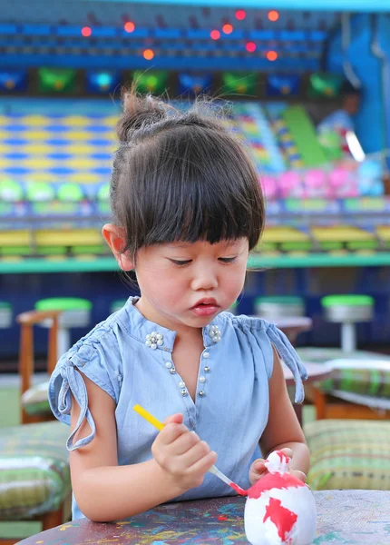 Peinture d'enfant, Portrait petite fille s'amusant à peindre sur poupée en stuc — Photo