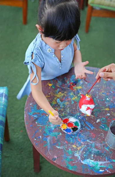 Kindermalerei, Portrait kleines Mädchen hat Spaß beim Malen auf Stuckpuppe — Stockfoto