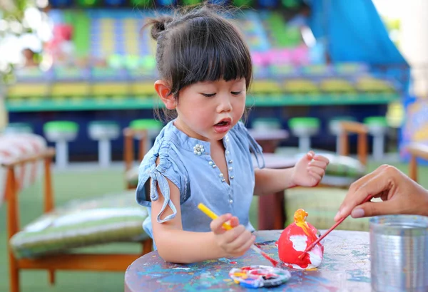 Peinture d'enfant, Portrait petite fille s'amusant à peindre sur poupée en stuc — Photo