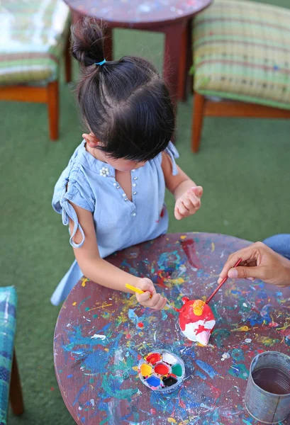 Child painting, Portrait little girl having fun to paint on stucco doll