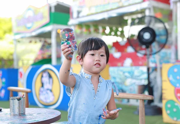 Pintura infantil, Retrato niña divirtiéndose para pintar en estuco muñeca — Foto de Stock