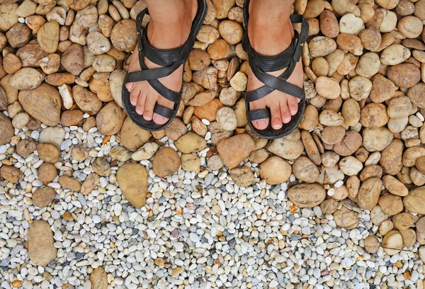 Дивлячись вниз на ноги на гравійні камені, прикрашені в саду — стокове фото
