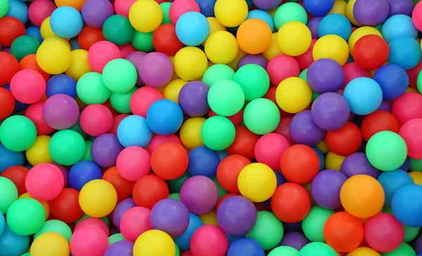 Wiele kolorowych plastikowych kulek na boisku dla dzieci na placu zabaw. — Zdjęcie stockowe
