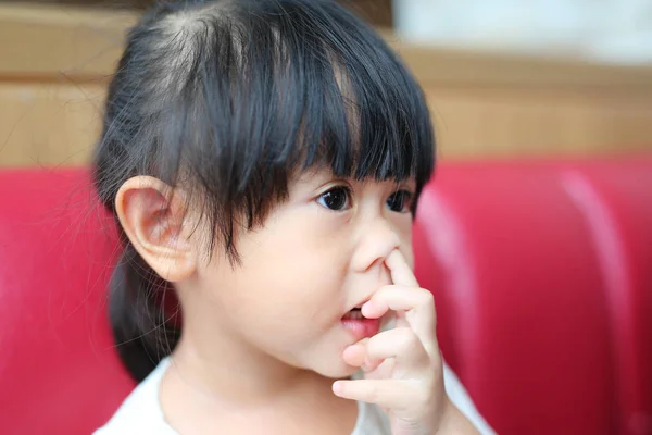 Porträtt av en liten asiatiska baby barn flicka på röd soffa — Stockfoto