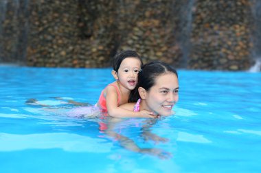 Açık Yüzme havuzunda oynayan annesi ile sevimli küçük kız