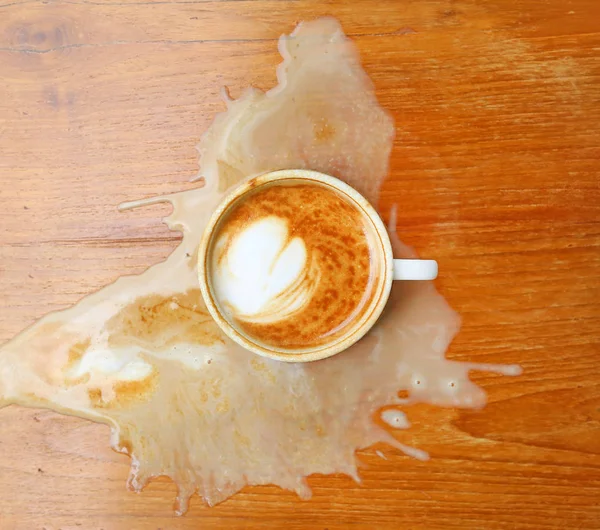Café derramado en la mesa de madera — Foto de Stock