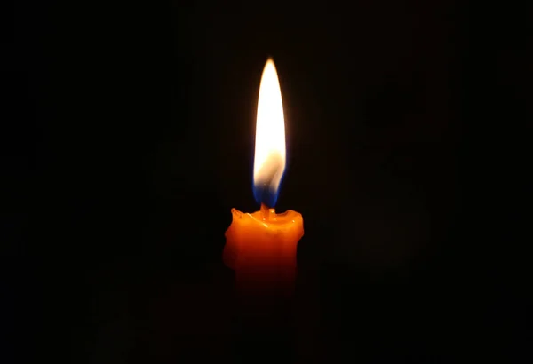 One candle burning brightly in the dark. — Stock Photo, Image