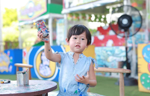 Pintura infantil, Retrato niña divirtiéndose para pintar en estuco muñeca — Foto de Stock