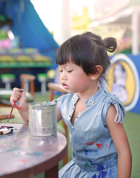Детская живопись, Портрет маленькой девочки весело рисовать на лепной кукле — стоковое фото