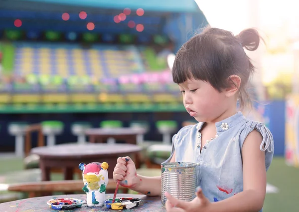 Peinture d'enfant, Portrait petite fille s'amusant à peindre sur poupée en stuc — Photo