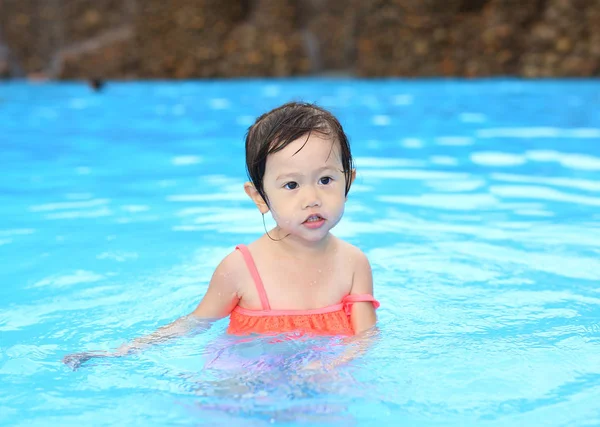 Gadis kecil yang cantik bermain di kolam renang di luar — Stok Foto