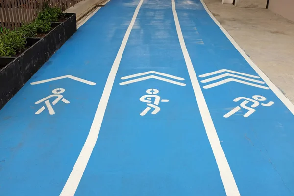 Pista de atletismo deportiva azul con cartel de caminar, correr y correr —  Fotos de Stock