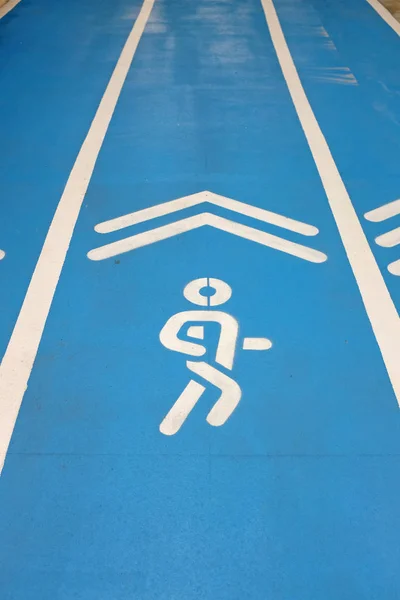 Pista de corrida esporte azul com jogging sinal — Fotografia de Stock