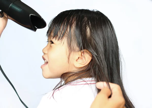 Μητέρα ξήρανσης μαλλιά της το παιδί κορίτσι σε λευκό φόντο — Φωτογραφία Αρχείου