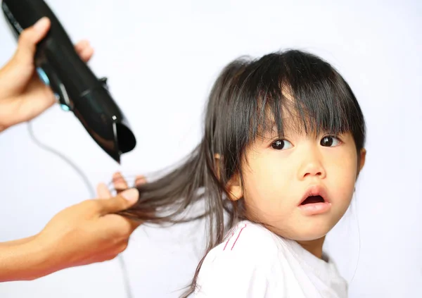 Madre secando el cabello de su niña sobre fondo blanco — Foto de Stock