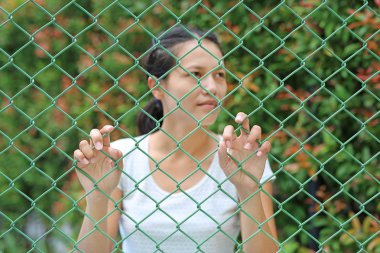 Çelik kafes, odak onun elinde tutan el ile açık Asyalı kadın dikkat et