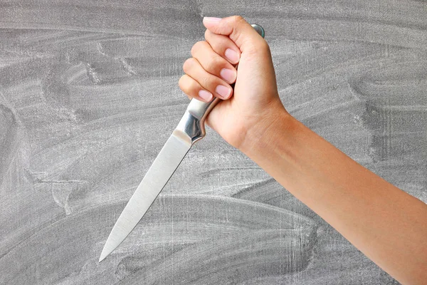 Hand hält ein Messer bereit, um auf Tafel-Hintergrund zuzuschlagen — Stockfoto