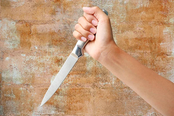 Hand hält ein Messer bereit, um gegen die rostige Wand zu schlagen — Stockfoto