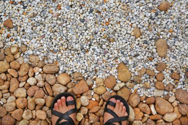Looking down at the feet on a gravel stones decorate in the garden clipart